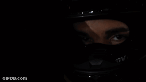 A Woman Wearing A Helmet Is Reflected In A Car Mirror GIF