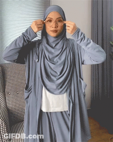 A Woman Wearing A Hijab Adjusts Her Glasses GIF