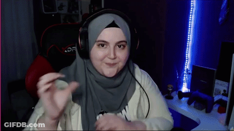 A Woman Wearing A Hijab And Headphones Is Sitting In A Chair GIF