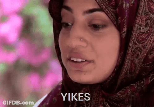 A Woman Wearing A Hijab Says " Yikes " In Front Of Her Face GIF