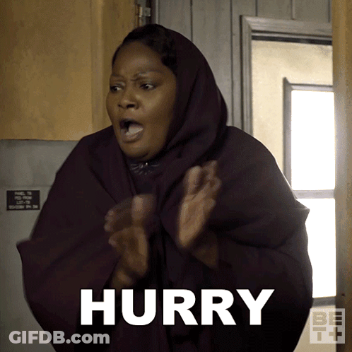A Woman Wearing A Hooded Cape Says Hurry With Her Hands In The Air GIF