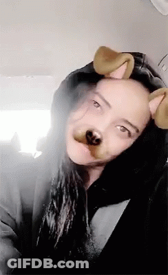 A Woman Wearing A Hooded Jacket And Dog Ears Looks At The Camera . GIF