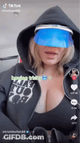 A Woman Wearing A Hoodie And A Blue Visor Is A Tiktok Video . GIF
