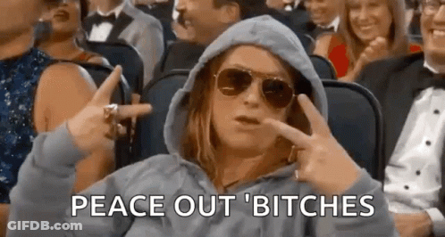 A Woman Wearing A Hoodie And Sunglasses Is Sitting In A Crowd Of People . GIF