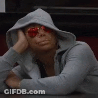A Woman Wearing A Hoodie And Sunglasses Rests Her Head On Her Hands GIF