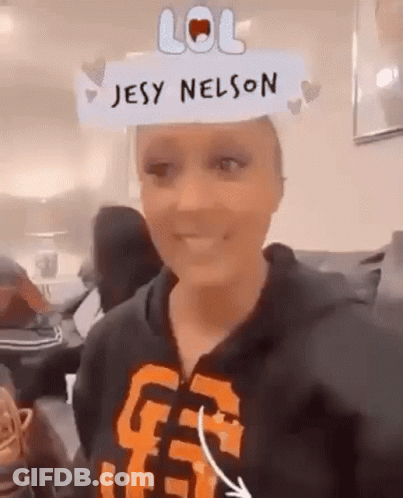 A Woman Wearing A Hoodie With The Name Jesy Nelson On Her Head . GIF