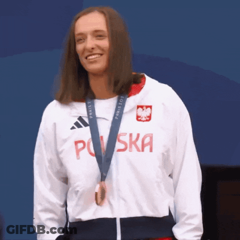 A Woman Wearing A Jacket That Says Polska Is Smiling GIF