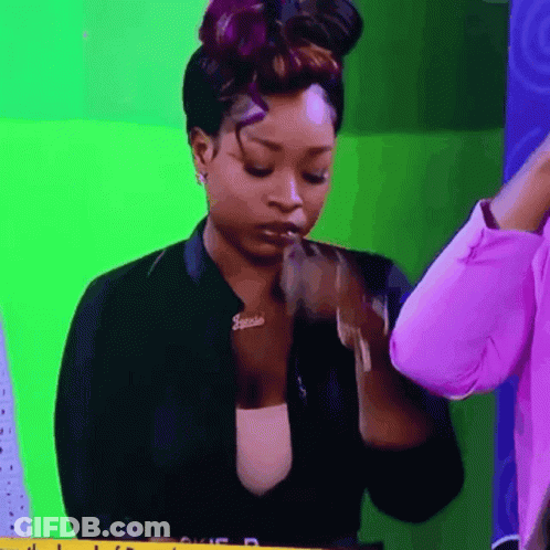 A Woman Wearing A Jacket With A Name Tag That Says Janelle GIF