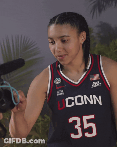 A Woman Wearing A Jersey That Says Uconn 35 On It GIF