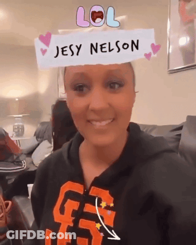 A Woman Wearing A Jesy Nelson Headband Smiles GIF
