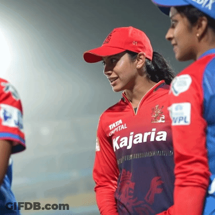 A Woman Wearing A Kajaria Jersey Is Standing Next To A Man GIF