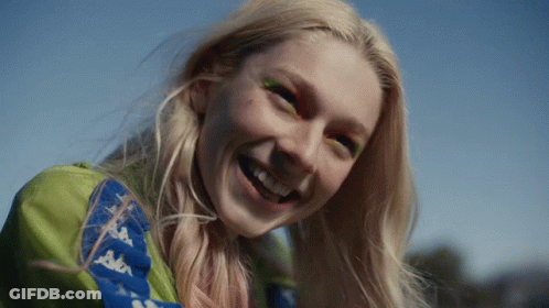 A Woman Wearing A Kappa Jacket Smiles With Her Eyes Closed GIF