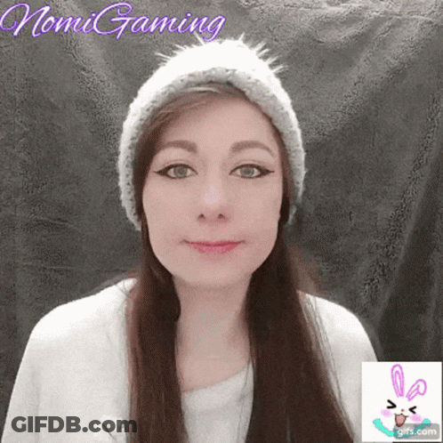 A Woman Wearing A Knitted Hat With The Name Nomi Gaming Written On The Bottom GIF