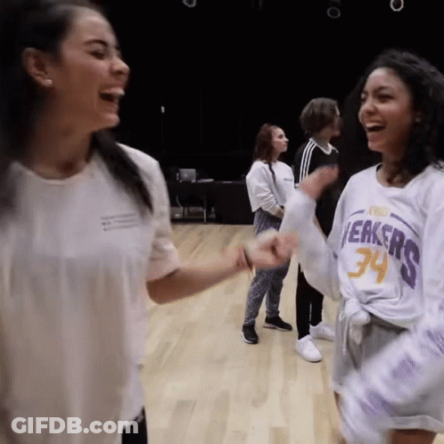 A Woman Wearing A Lakers Jersey Laughs With Another Woman GIF