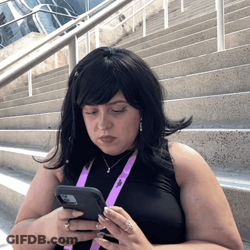 A Woman Wearing A Lanyard That Has The Letter T On It GIF