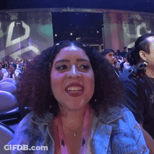 A Woman Wearing A Lanyard That Says ' I Love You ' On It Smiles GIF