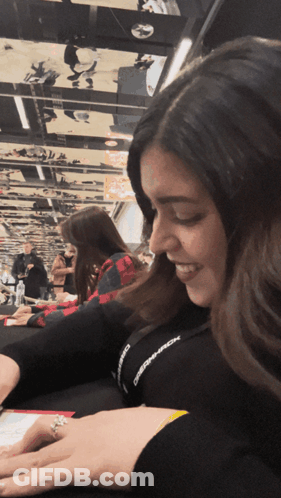 A Woman Wearing A Lanyard That Says ' Observer ' On It Smiles GIF