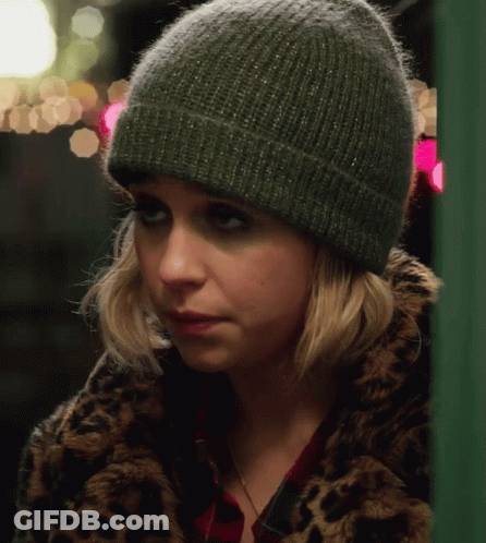 A Woman Wearing A Leopard Print Coat And A Green Beanie GIF