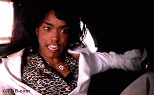 A Woman Wearing A Leopard Print Shirt And A White Jacket Is Sitting In A Car GIF