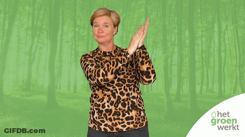 A Woman Wearing A Leopard Print Shirt Stands In Front Of A Green Background With Het Groen Werkt Written On It GIF