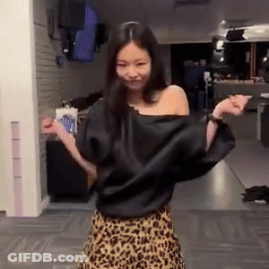A Woman Wearing A Leopard Print Skirt And A Black Top Is Dancing In A Room . GIF