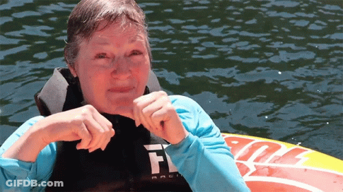 A Woman Wearing A Life Jacket With The Letter F On The Front GIF