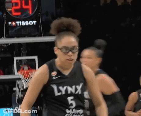 A Woman Wearing A Lynx 5 Jersey Stands In Front Of A Scoreboard GIF