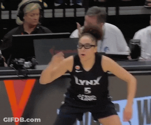 A Woman Wearing A Lynx 5 Jersey Stands On A Bench GIF