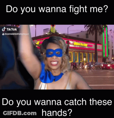 A Woman Wearing A Mask And A Superhero Costume Says Do You Wanna Fight Me Do You Wanna Catch These Hands GIF