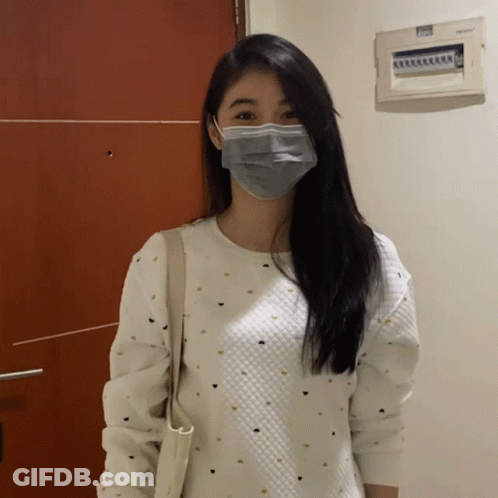 A Woman Wearing A Mask And A White Sweater GIF
