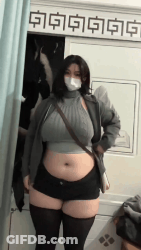 Woman In Mask And Shorts Standing In Front Of A Sign GIF