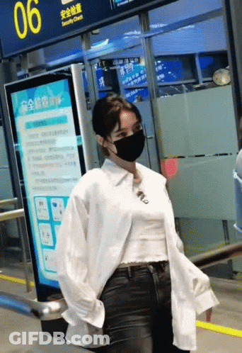Woman Wearing Mask Standing In Front Of Sign 06 GIF