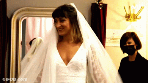 A Woman Wearing A Mask Is Standing Next To A Woman Wearing A Veil GIF