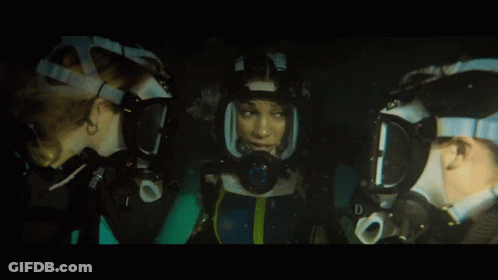 A Woman Wearing A Mask With The Letter D On It Looks At Another Woman GIF