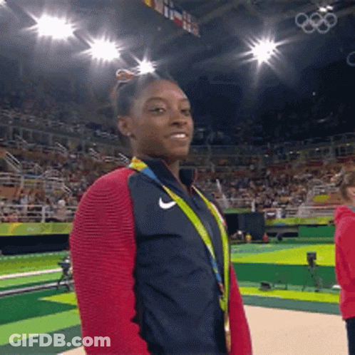 A Woman Wearing A Medal And A Nike Jacket GIF