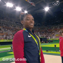 A Woman Wearing A Medal And A Nike Jacket GIF