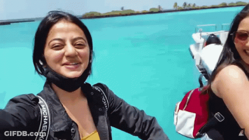 A Woman Wearing A Michael Kors Jacket Smiles While Taking A Selfie GIF