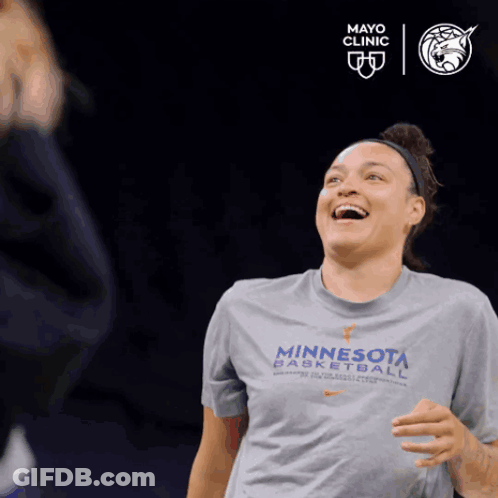 A Woman Wearing A Minnesota Basketball T-Shirt Is Laughing GIF