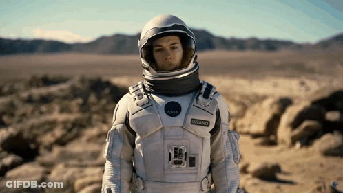 A Woman Wearing A Nasa Space Suit And Helmet GIF