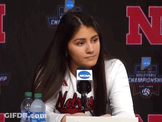 A Woman Wearing A Nebraska Shirt Is Sitting At A Desk With A Microphone GIF