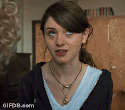 A Woman Wearing A Necklace And A Black Hoodie Looks Up GIF