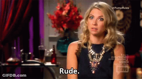A Woman Wearing A Necklace And A Black Top Is Talking To Someone And Saying Rude . GIF