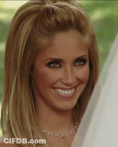 A Woman Wearing A Necklace And A Veil Smiles For The Camera GIF