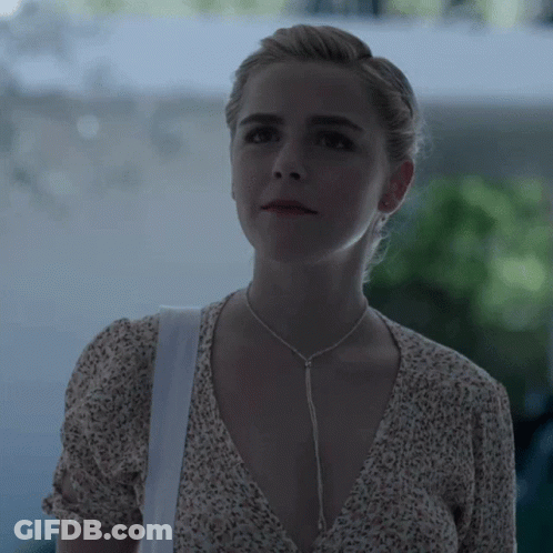 A Woman Wearing A Necklace And A White Bag GIF