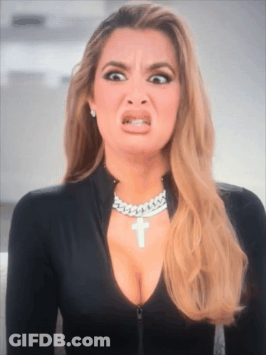 A Woman Wearing A Necklace With A Cross On It GIF