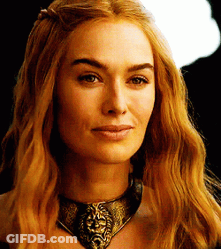 A Woman Wearing A Necklace With A Lion Head On It GIF