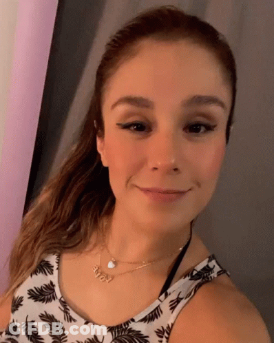 A Woman Wearing A Necklace With The Name Amy On It Smiles For The Camera GIF