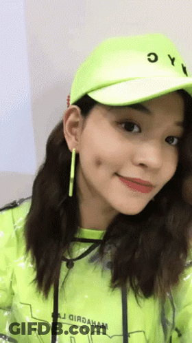A Woman Wearing A Neon Green Hat And A Yellow Jacket GIF