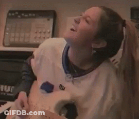 A Woman Wearing A New York Giants Jersey Is Playing A Guitar GIF