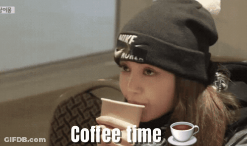 A Woman Wearing A Nike Beanie Is Drinking Coffee GIF